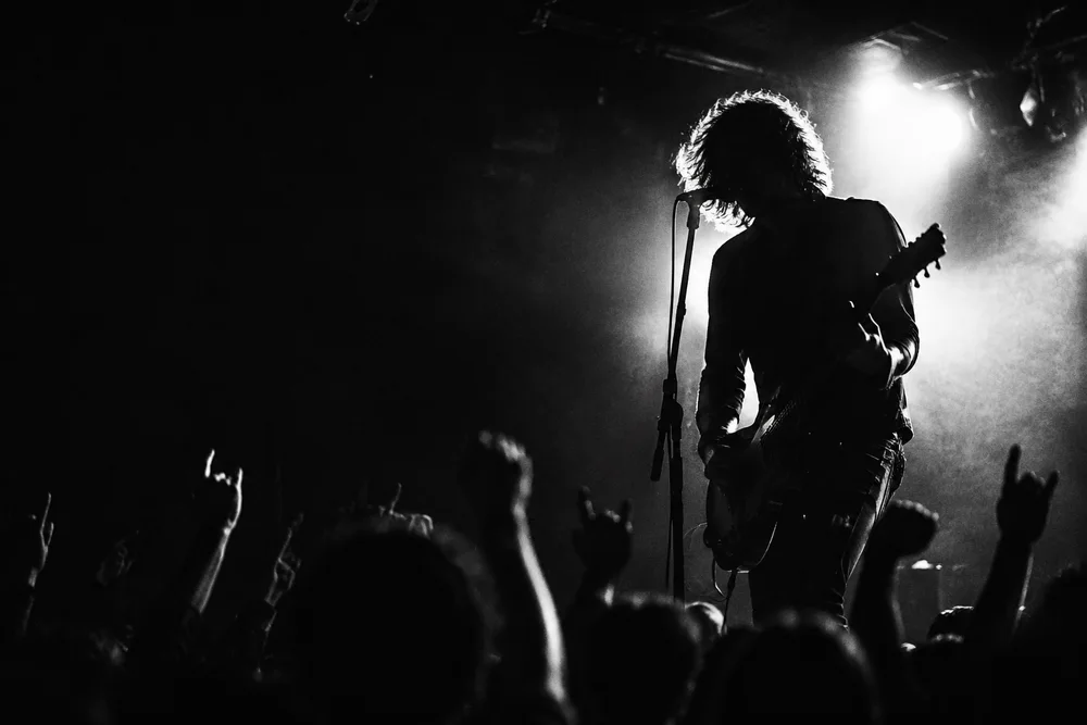Guitarist playing to a crowd in a small live music venue